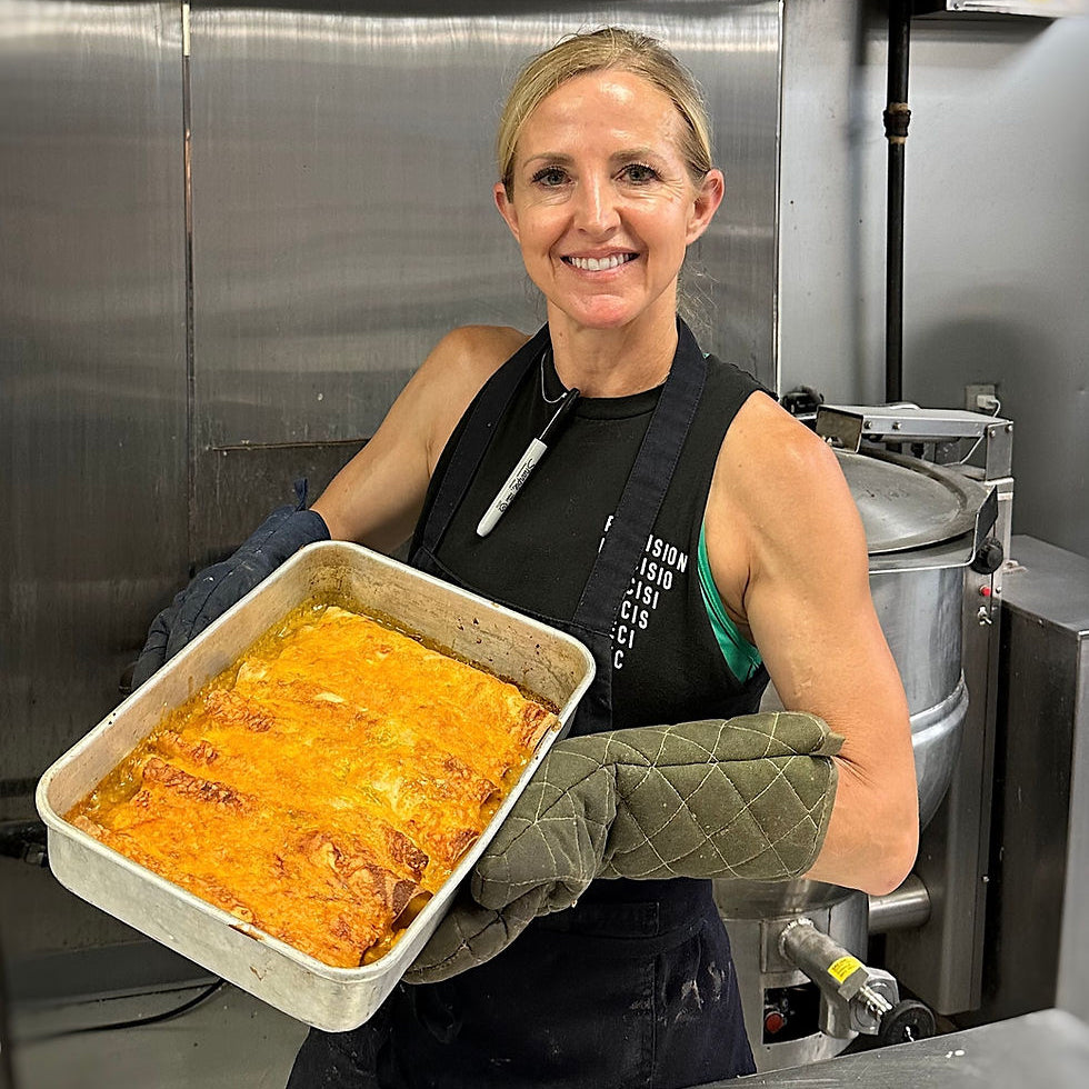 Woman holding a tray of lasagna in a kitchen setting
